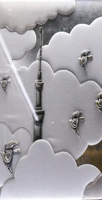 雲の間から顔を出す東京スカイツリーを立体的に表現した、金属調のレリーフ加工のアートパネル。