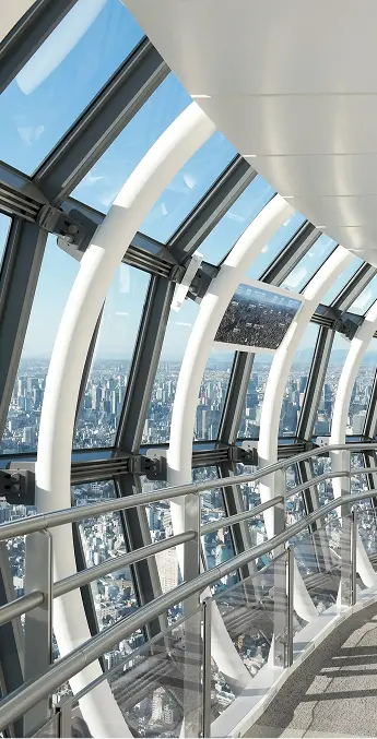天望回廊の内部。緩やかにカーブする白い鉄骨の柱と、その向こうに広がる東京の街並み。