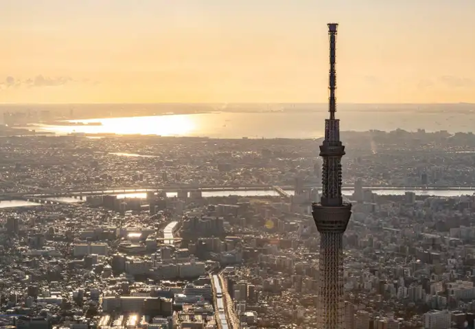夕暮れの空と街並みを背景にそびえ立つ東京スカイツリーの景色