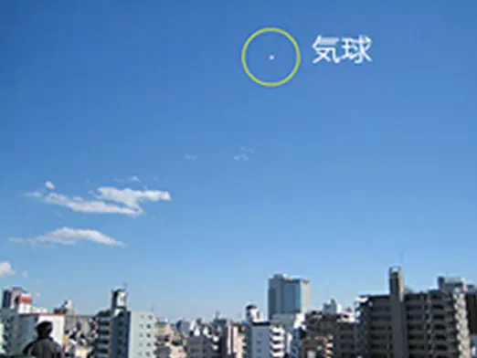 青空の上空に浮かぶ気球を示し、「気球」と表示されたビジュアル