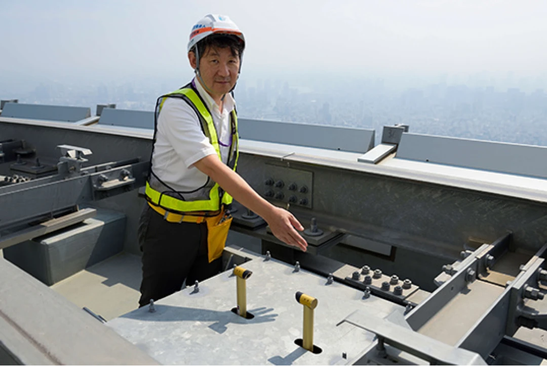 高所の大規模構造物で点検作業を行うヘルメット姿の技術者