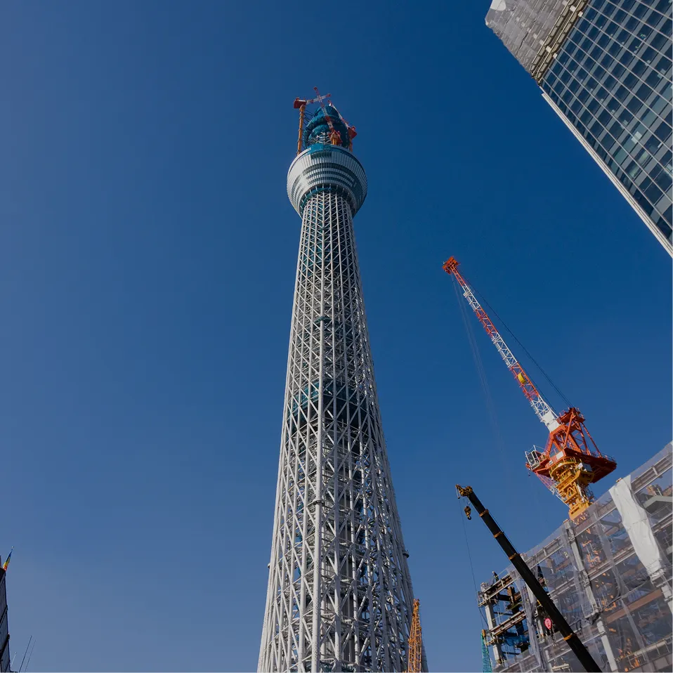 建設中の東京スカイツリーと青空に伸びるクレーン