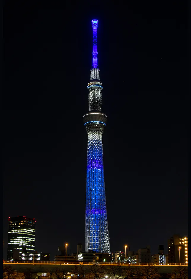 2020年3月27日、青色の特別ライティングとレーザーマッピングによるメッセージを投影する東京スカイツリーの夜景