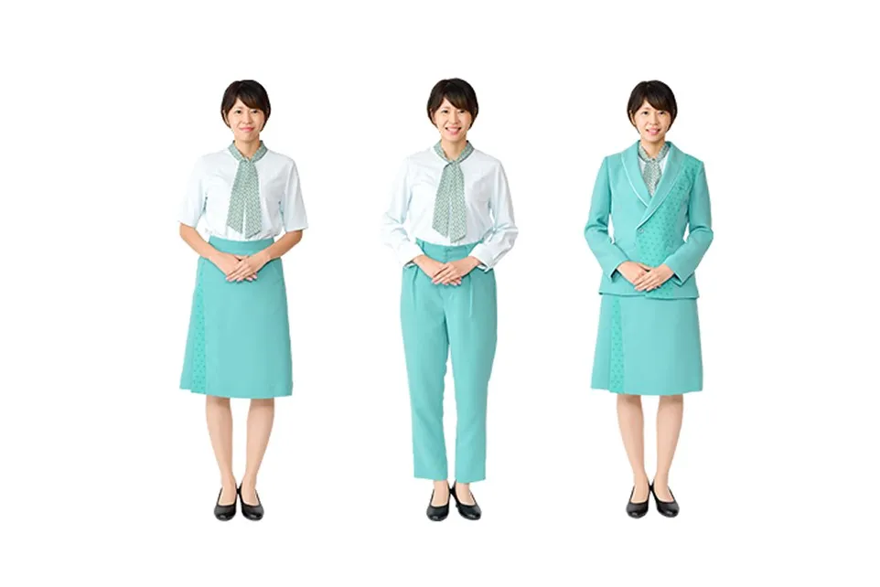 Three Uniform patterns for female Information Staff . From left to right, they are a combination of a short-sleeved blouse and skirt, a long-sleeved blouse and pants, and a jacket and skirt. The colors are a refreshing mint green and white, and a Japanese-patterned scarf is tied around the neck like a tie.
