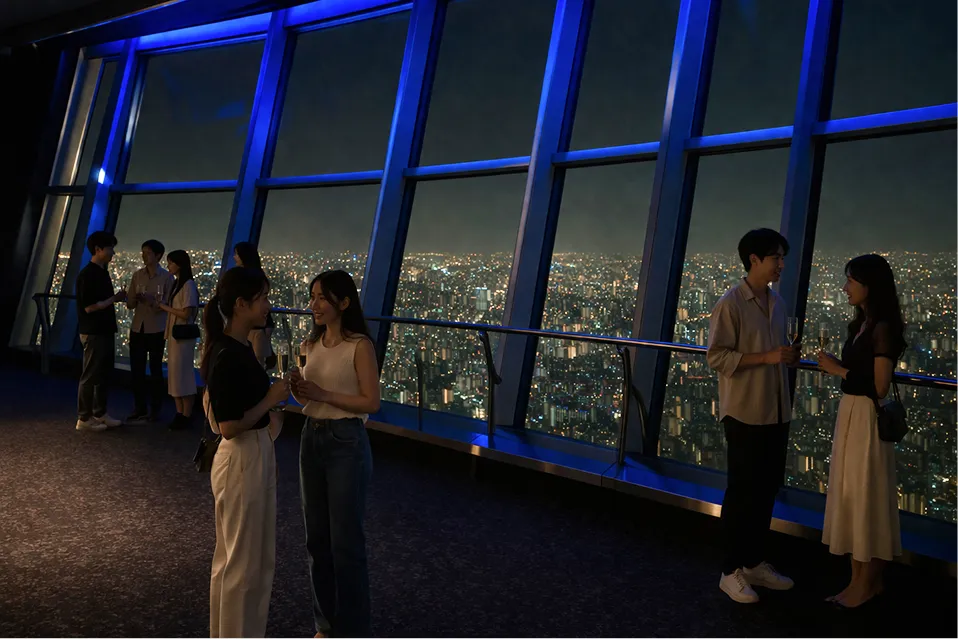 展望台でグラスを持ってイベントを楽しむ人々