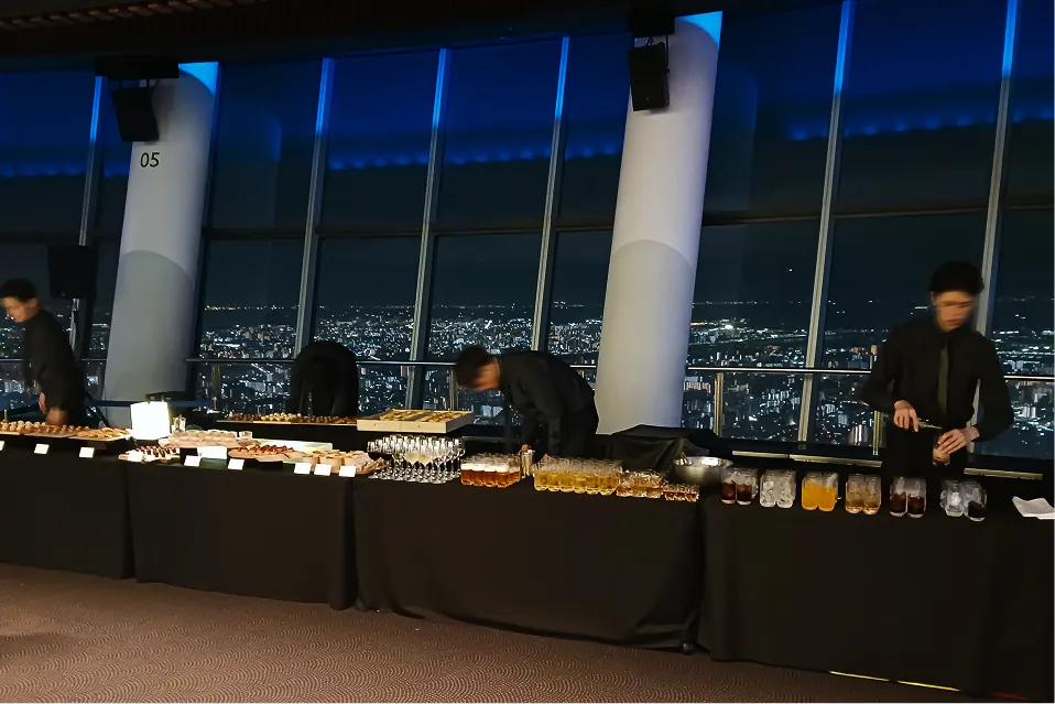 立食用の食事をカウンターに用意しているスタッフたち