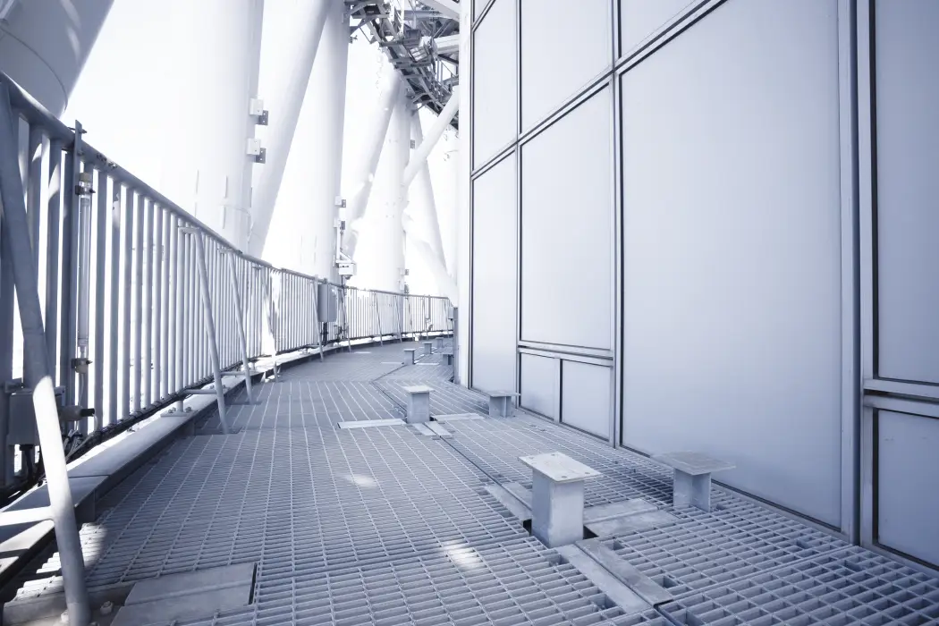 手すりと金属メッシュの床面がある、屋外に面した開放的な機器設置エリア