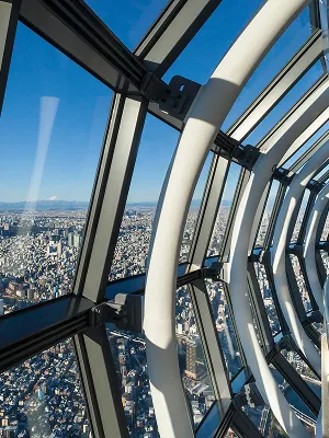 幾何学的なデザインの鉄骨構造が印象的な展望台の天井部分。高い吹き抜けの構造越しに、青空の一部がのぞいている。