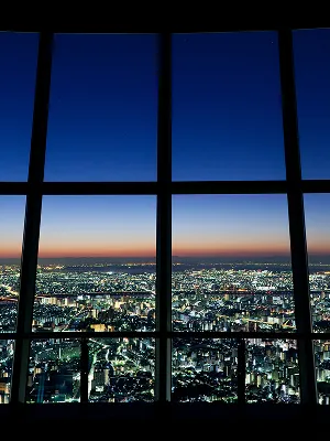 展望台の窓枠越しに切り取られた、日没直後のトワイライトの空。空が深い青からオレンジ色へと変化する美しいグラデーション。