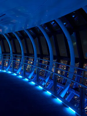 展望台の外周に設置された、青く光る照明の列。湾曲した通路に沿って並ぶ光が、夜の都会的な空間を演出している。