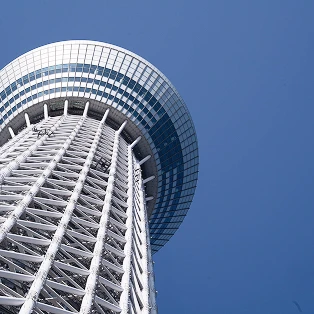 下から見上げた東京スカイツリーと、青空にせり出す天望デッキの裏側。