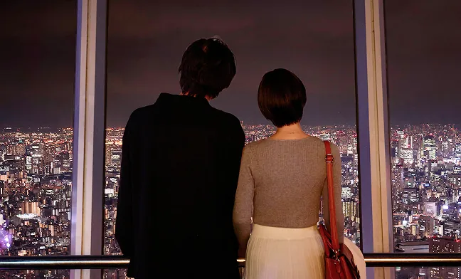 夜景を眺める男女の後ろ姿