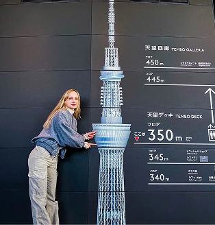 東京スカイツリーのフロア案内パネルを指差す女性