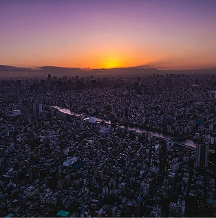 夕暮れ時にオレンジ色に染まる東京の街並みと川の風景