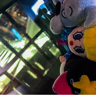 夜景を背景に窓際に置かれたソラカラちゃんなどのぬいぐるみ