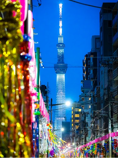 夏らしい七夕飾り越しに見上げる、夕暮れ時の東京スカイツリー