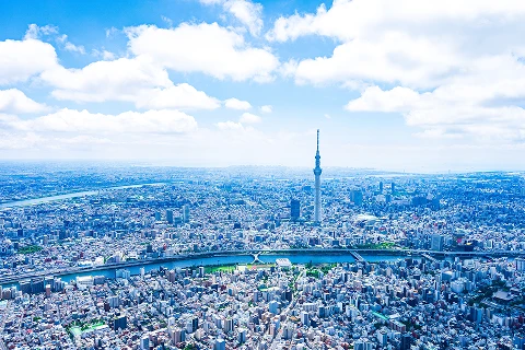青空の下に広がる東京の街並みと中央にそびえ立つ東京スカイツリー