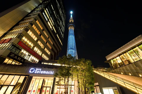 下から見上げた東京ソラマチの建物と夜空に光る東京スカイツリー