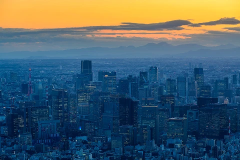 オレンジ色から青へのグラデーションの空と夕暮れの街並み