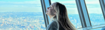 展望台の窓から景色を見つめる女性の横顔