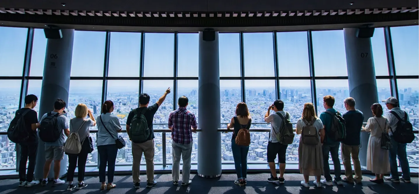 東京スカツリーの展望台から東京の景色を眺める観光客たちの後ろ姿