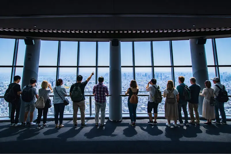 東京スカツリーの展望台から東京の景色を眺める観光客たちの後ろ姿