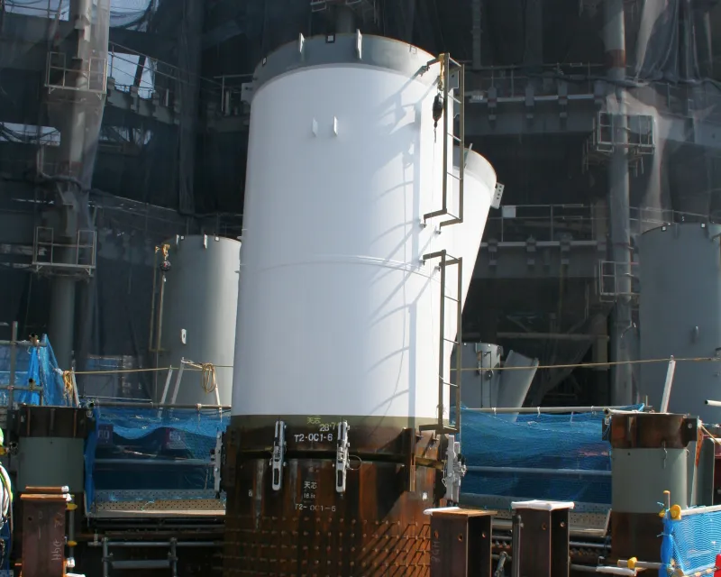 巨大な塔体鉄骨をクレーンで吊り上げて設置する最初の鉄骨取付け工事の様子