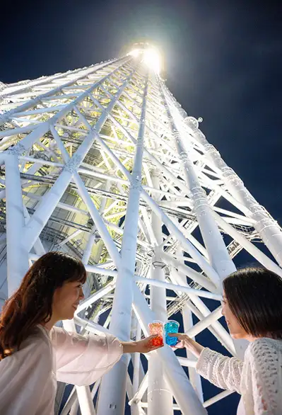 ライトアップされた東京スカイツリーを見上げる様子
