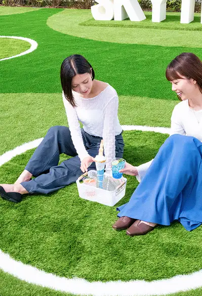 芝生の上でピクニックを楽しむ女性二人