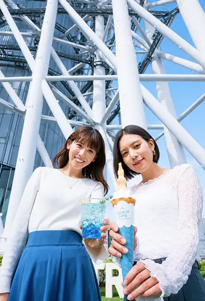 東京スカイツリーの鉄骨を背景にドリンクを持つ女性二人