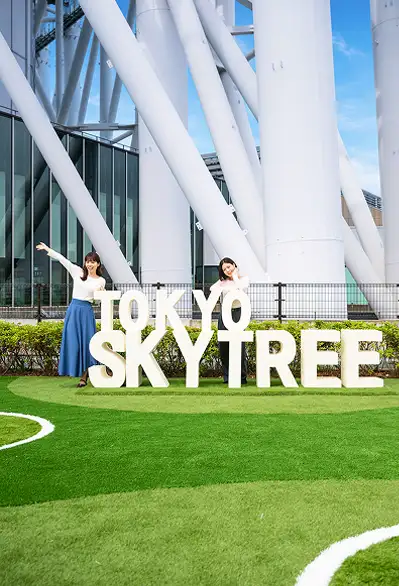 東京スカイツリーの文字モニュメントの前でポーズを取る女性達