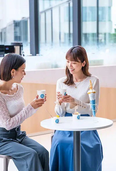 明るいカフェ店内で会話を楽しむ女性二人