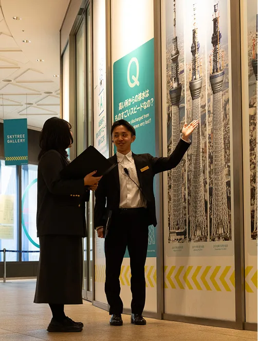 大きな窓の前に立つスーツ姿のスタッフたち