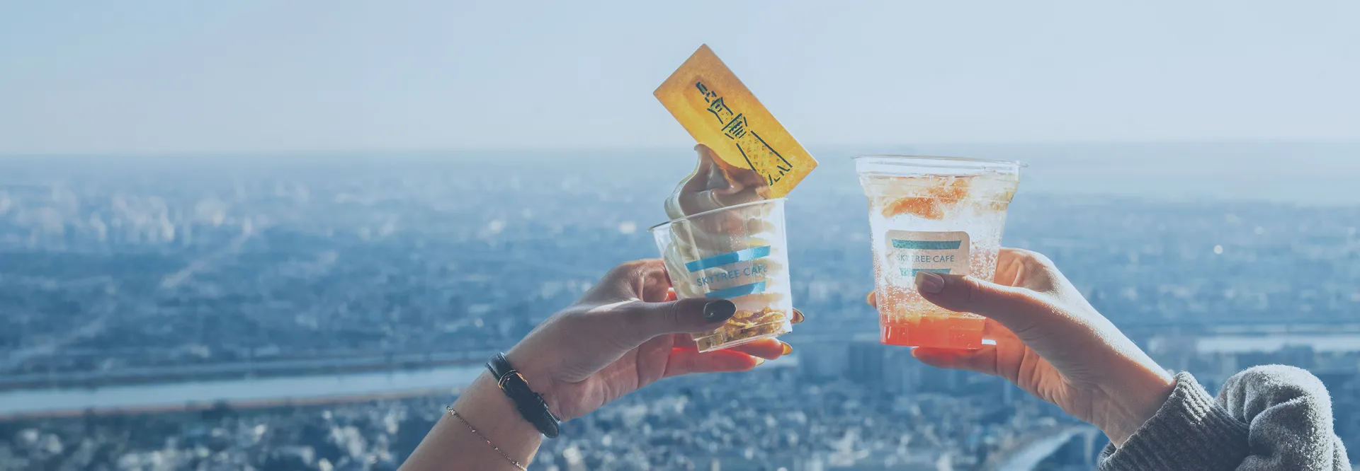 晴れ渡る街並みを眼下に、展望デッキで楽しむソフトクリームとフルーツソーダ