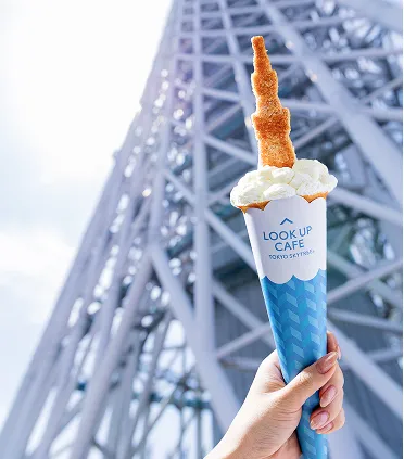 東京スカイツリーを背景にした、クリームと東京スカイツリー型のお菓子がのったクレープ