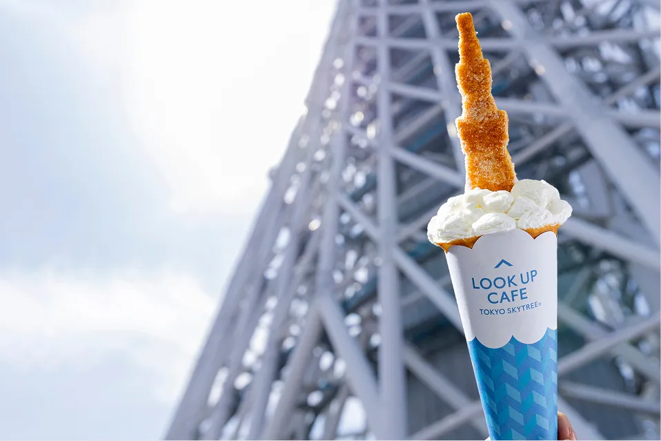 東京スカイツリーを背景にした、クリームと東京スカイツリー型のお菓子がのったクレープ