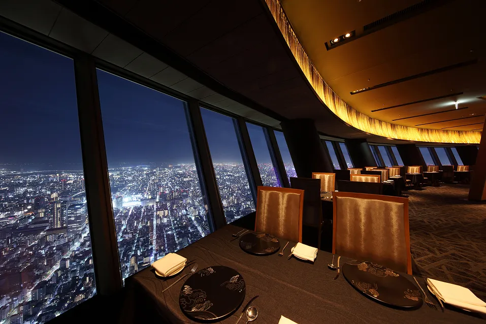 手前にセットされたディナーテーブル、そのすぐ横の大きな窓いっぱいに広がる、宝石を散りばめたような東京の夜景。眼下には街の灯りが地平線まで続いています。