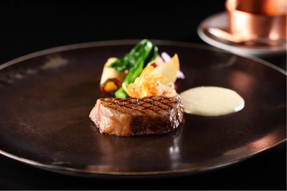 シックな黒いプレートに盛り付けられた色鮮やかな料理。