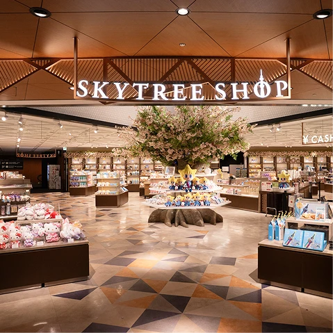 大きなシンボルツリーを中心に広がる明るい店内の様子とギフト商品が並ぶ売り場風景