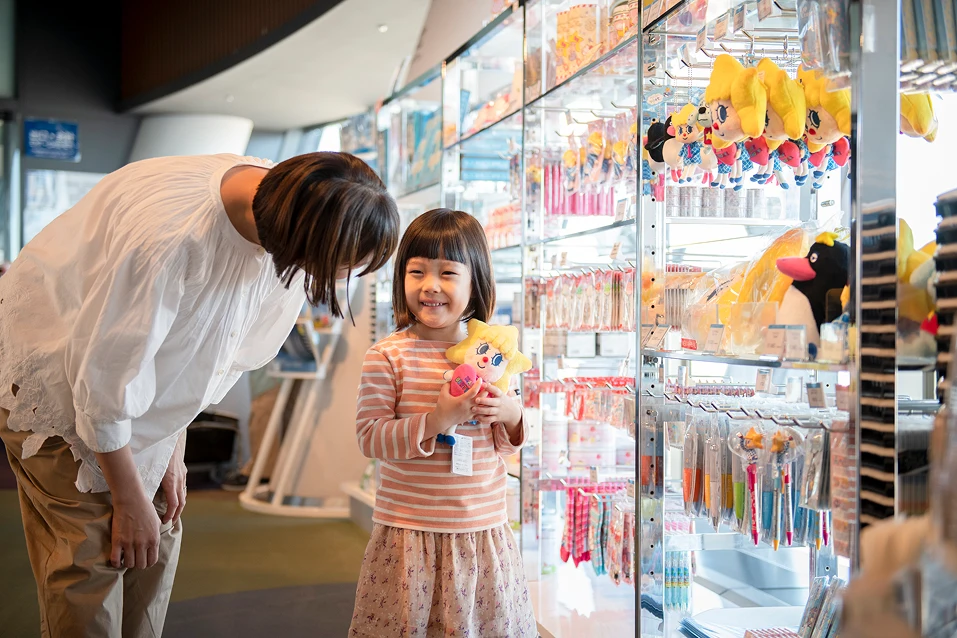 子どもと保護者がキャラクターグッズを選ぶ店内の様子