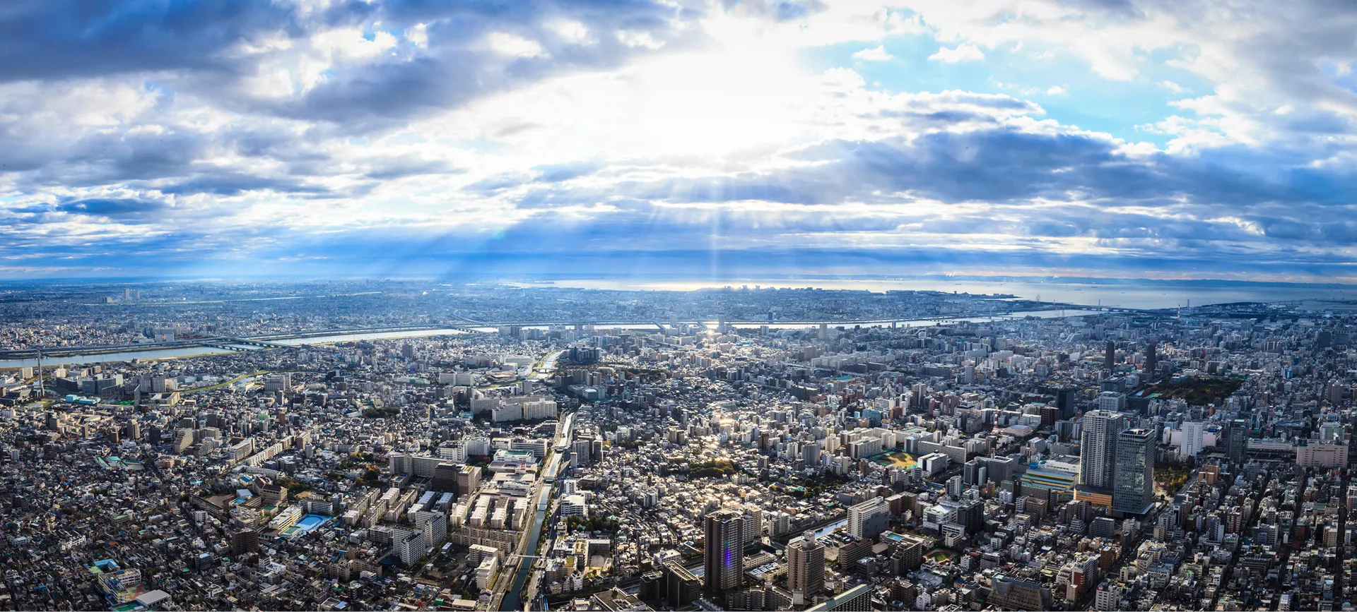 厚い雲の隙間から光が差し込む、広大な東京の街並み。