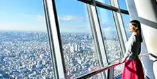 東京スカイツリー展望台から遠くの景色を眺める女性